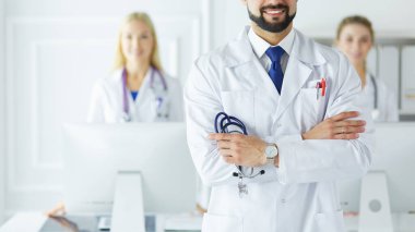 Tıbbi grubun önünde genç bir erkek doktor.