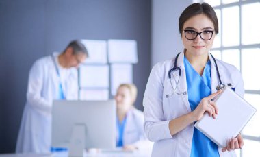 Hastane lobisinde tablet bilgisayar kullanan kadın doktor.