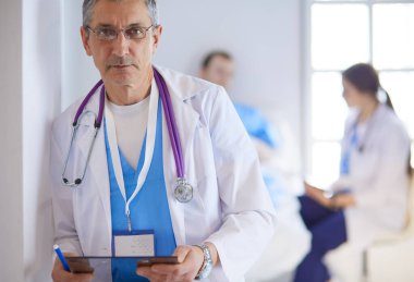 Doktor bir hastanın ve doktorun önünde klasörü tutuyor.