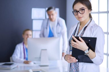 Kadın doktor hastanede steteskopla dikiliyor.