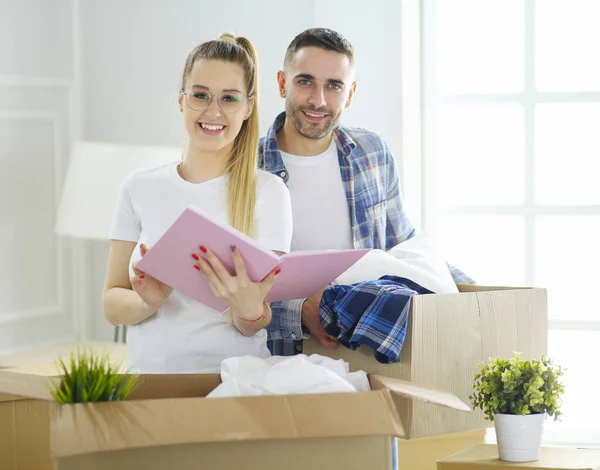 Ein frisch verheiratetes Paar packt Kartons aus und bezieht ein neues Zuhause. Positive Emotionen. — Stockfoto