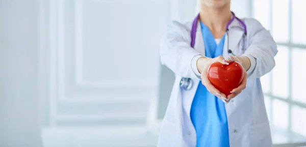 女医生用听诊器把心脏抱在怀里。医学中的医疗保健和心脏病学概念 — 图库照片