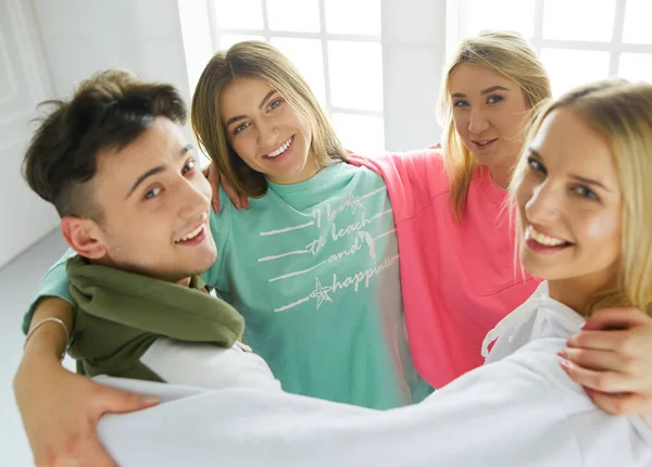 Heureux amis souriants, groupe de jeunes debout et embrassant ensemble — Photo