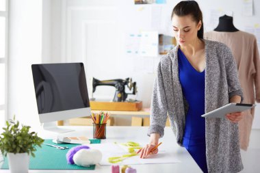 Moda tasarımcısının stüdyosunda çalışan portresi.