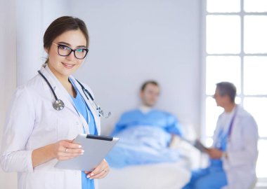 Hastane lobisinde tablet bilgisayar kullanan kadın doktor.