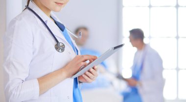 Hastane lobisinde tablet bilgisayar kullanan kadın doktor.