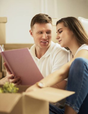 Yeni evlerinde karton kutuları açan sevimli bir çift.