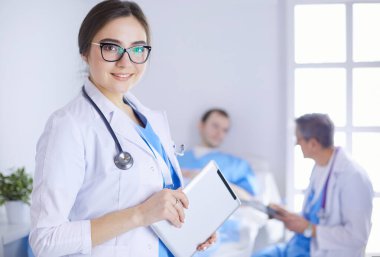 Hastane lobisinde tablet bilgisayar kullanan kadın doktor.