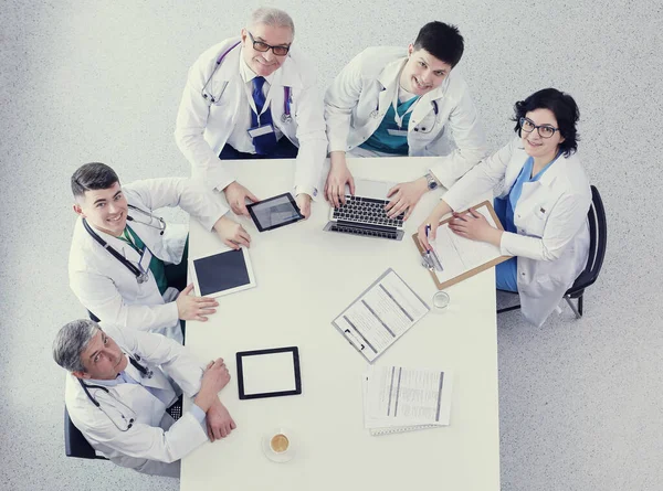 Medical team sitting and discussing at table, top view