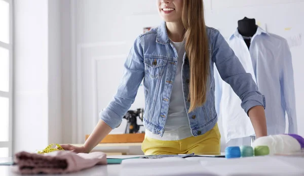 Hermoso diseñador de moda de pie cerca del escritorio en el estudio — Foto de Stock