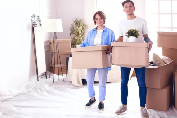 Uma menina e um cara segurando caixas para mover as mãos e olhando dentro da caixa — Fotografia de Stock