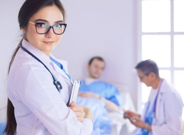 Hastane lobisinde tablet bilgisayar kullanan kadın doktor.