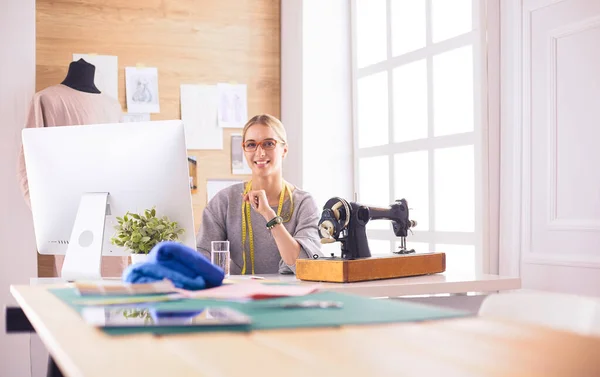 Vacker ung flicka i en fabrik med symaskin vid bordet — Stockfoto