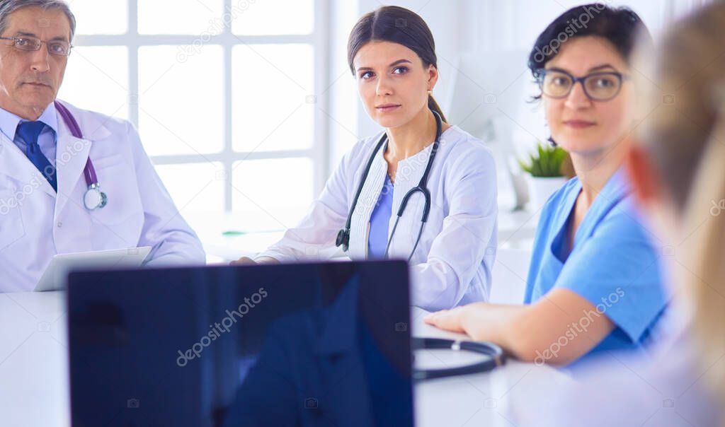 Serious medical team discussing patients case in a bright office