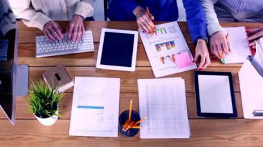 İş arkadaşlarının elleri yukarıdan ahşap masa üzerinde çalışıyor, beyin fırtınası ekibi toplantısı, üst görüş.