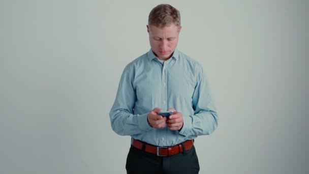 Mensaje de texto de hombre de negocios en su teléfono en el fondo gradiente — Vídeo de stock