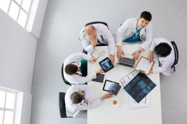 Tıbbi ekip masaya oturuyor ve tartışıyor.