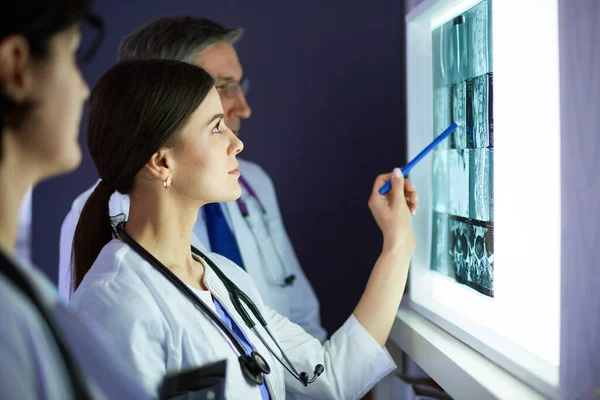 Grupo de médicos examinando raios-x em uma clínica, pensando em um diagnóstico — Fotografia de Stock