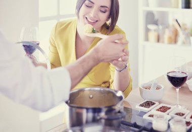 Evdeki mutfakta birlikte yemek pişiren çift.