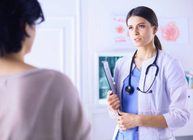 Güzel bayan doktor bir hastaya tıbbi tedaviyi açıklıyor.