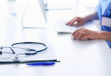 Masada oturan gülümseyen güzel genç bayan doktor.