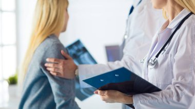 Doktor ve hasta tarama sonuçlarını tarama merkezinde tartışıyor