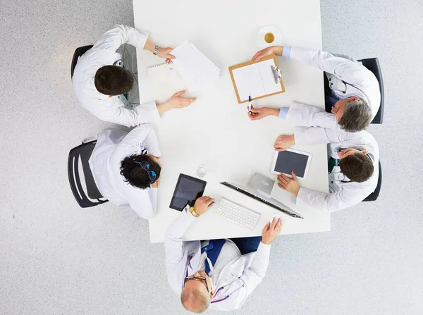 Medisch team zit en discussieert aan tafel, bovenaanzicht — Stockfoto