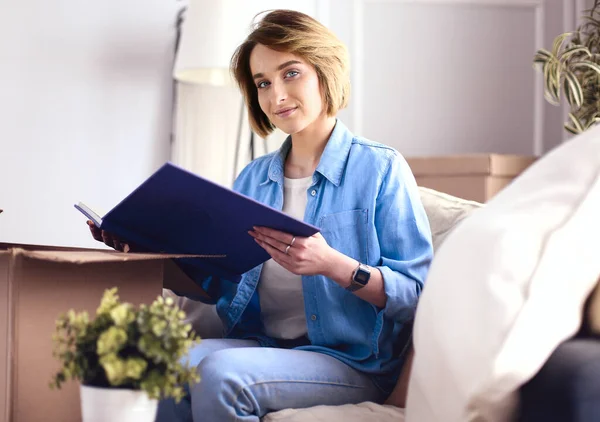 Ung kvinna flyttar ut och packar pappkartong — Stockfoto