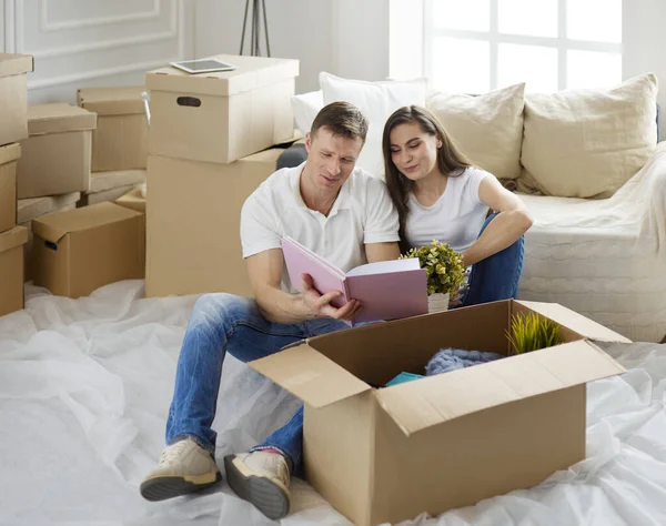Χαριτωμένο ζευγάρι ξεπακετάρει κουτιά από χαρτόνι στο νέο τους σπίτι — Φωτογραφία Αρχείου