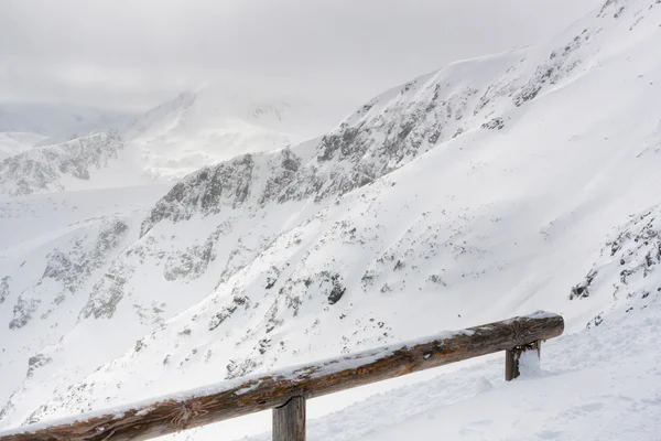 Panorama de neve paisagem de montanha com nevoeiro e nuvens — Fotografia de Stock