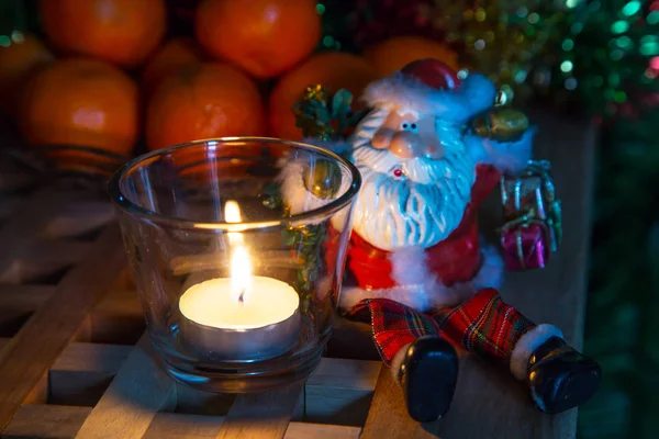 Christmas background tea candles and toy Santa — Stock Photo, Image