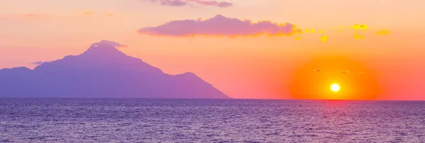 Silhouette du mont Athos au lever ou au coucher du soleil avec des rayons de lumière et panorama sur la mer — Photo