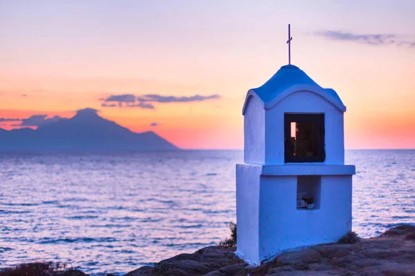 Pequeña capilla griega y monte Athos al amanecer o al atardecer con panorama del mar —  Fotos de Stock