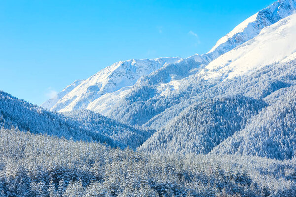 Mountains peaks and blue sky with clouds background