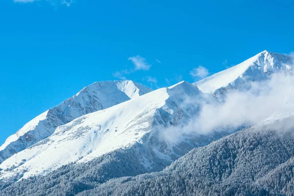 Bergstoppar och blå himmel med moln bakgrund — Stockfoto