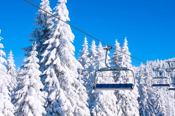 Ski resort afbeelding met de stoeltjeslift en pijnbomen van de witte sneeuw — Stockfoto