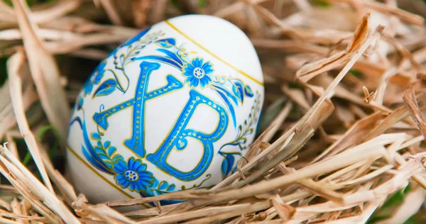 Fond de vacances vibrant avec oeuf de Pâques traditionnel russe coloré dans un nid d'herbe sèche — Photo