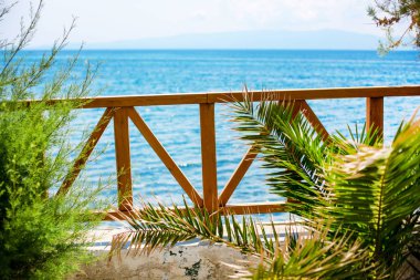 Avuç içi mavi deniz manzarası ile ahşap teras manzarası
