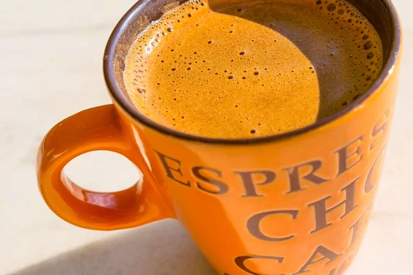 Grande xícara de café laranja na mesa closeup — Fotografia de Stock