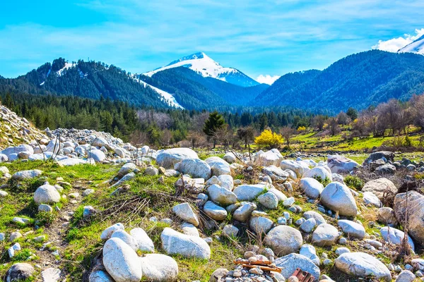 Весенний фон с вершинами снежных гор, камнями — стоковое фото
