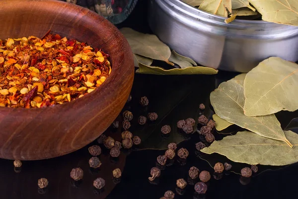 Especias y hierbas, hoja de laurel, pimienta negra y tazón de madera de hojuelas de chile —  Fotos de Stock