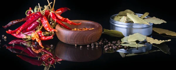 Spezie ed erbe aromatiche, alloro, pepe nero e ciotola di legno di fiocchi di peperoncino — Foto Stock