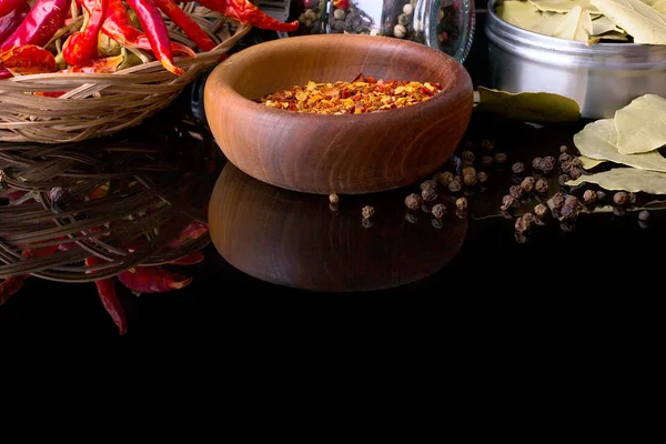 Specerijen en kruiden, laurier, zwarte peper en houten kom van chili vlokken — Stockfoto