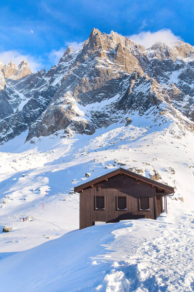 Деревянный дом и панорама высоких гор
