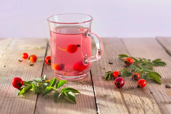 Tè rosa canina in tazza di vetro su sfondo di legno — Foto Stock