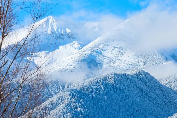 Горы вершины и голубое небо на фоне облаков — стоковое фото