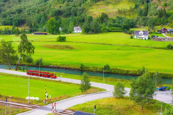 Flam, Norsko červená cesta vlakem v zeleném údolí — Stock fotografie