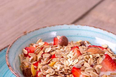 Taze çilekli yoğurt ve müsli kasesi.