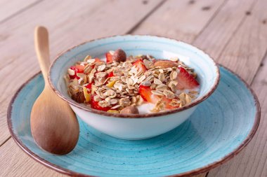 Taze çilekli yoğurt ve müsli kasesi.