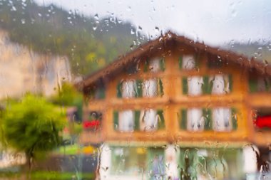House in rainy weather through the wet window clipart